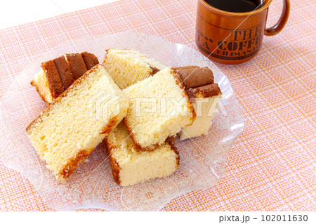皿に盛ったアウトレットの切り落としカステラとコーヒー 102011630