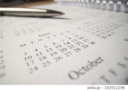 Iron pen lies on notepad page with year calendar on table 102012296