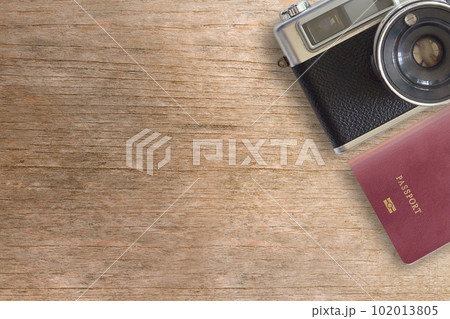 Vintage Camera and Passport on Wooden Background Vintage Camera and Passport on Wooden Background 102013805