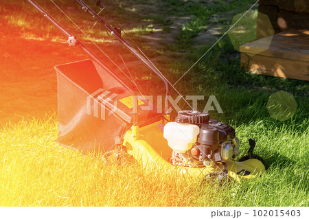 lawn mower on a sunny day, man mowing the lawn in the backyard 102015403