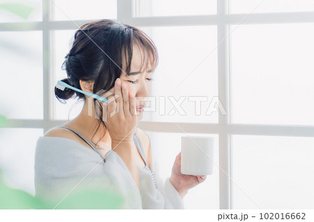 虫歯が痛い・しみて頬を押さえるアジア人女性の横顔 虫歯が痛い・しみて頬を押さえるアジア人女性の横顔 102016662