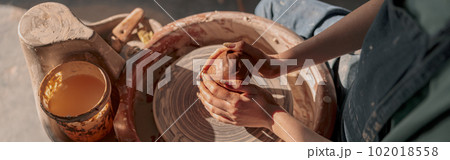 Clay artist modeling product on potter wheel in workshop 102018558