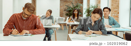 Group of university students taking a test Group of university students taking a test 102019062