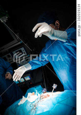 Surgeon's hands over the operating table in the bright light of surgical lamps. 102019134