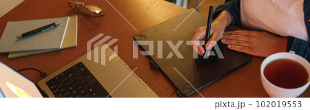 Cropped image of a graphic designer using digital tablet in his work at home office Cropped image of a graphic designer using digital tablet in his work at home office 102019553