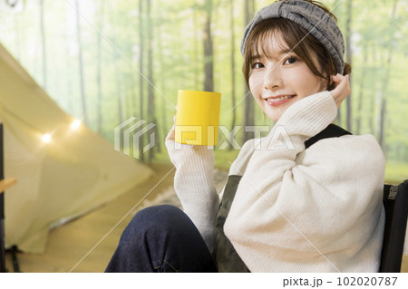 室内キャンプ場で飲み物を飲む若い女性　家キャン 102020787