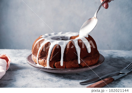 Bundt cake. Drizzling icing on homemade pound, cake. Bundt cake. Drizzling icing on homemade pound, cake. 102021144