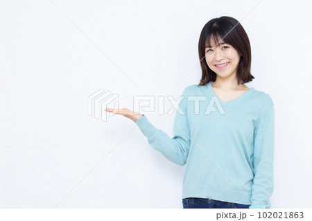 白背景の前で紹介をしている30代の女性 102021863