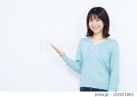 白背景の前で紹介をしている30代の女性 白背景の前で紹介をしている30代の女性 102021865