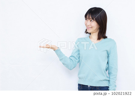 白い背景の前で紹介をしている30代の女性 102021922