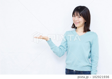 白い背景の前で紹介をしている30代の女性 白い背景の前で紹介をしている30代の女性 102021936