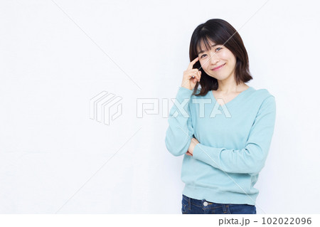 白い背景の前で紹介をしている30代の女性 白い背景の前で紹介をしている30代の女性 102022096