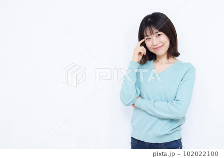 白い背景の前で紹介をしている30代の女性 白い背景の前で紹介をしている30代の女性 102022100
