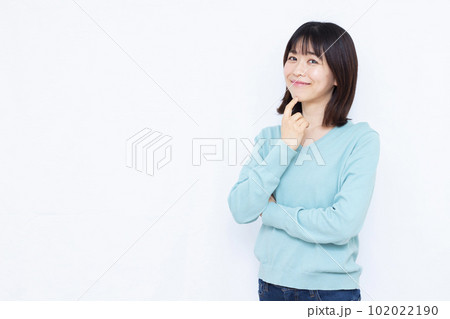 白い背景の前で紹介をしている30代の女性 白い背景の前で紹介をしている30代の女性 102022190