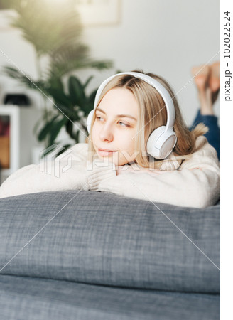 Young caucasian woman relaxes at home with music 102022524
