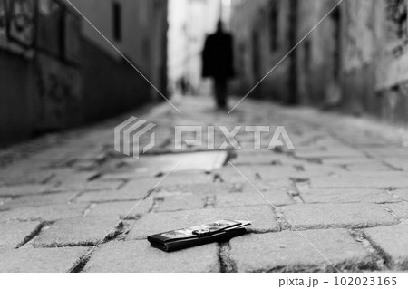 Photo of the sidewalk and legs of a man who lost a black leather wallet while walking 102023165