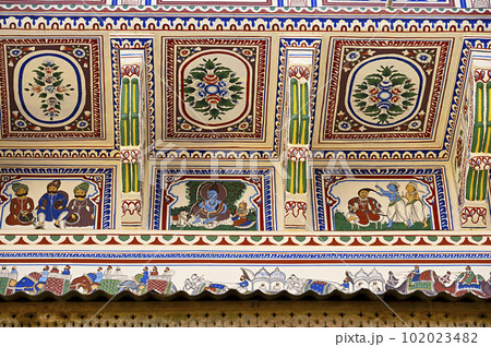 Colourful paintings and wooden windows on the outer wall of Seth Harmukhrai Sanehiram Chokhani Double Haveli, located in Mandawa, Shekhawati, Rajasthan, India Colourful paintings and wooden windows on the outer wall of Seth Harmukhrai Sanehiram Chokhani Double Haveli, located in Mandawa, Shekhawati, Rajasthan, India 102023482