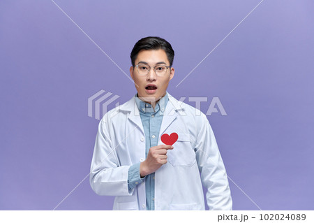 cardiologist doctor man holding red heart over purple background with angry face cardiologist doctor man holding red heart over purple background with angry face 102024089