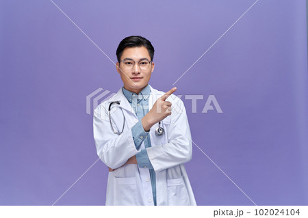 Medical concept of professional male doctor pointing with hand on copy space 102024104