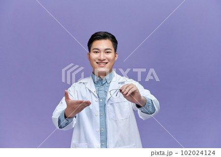 Male optometrist holding eyeglasses in clinic Male optometrist holding eyeglasses in clinic 102024124