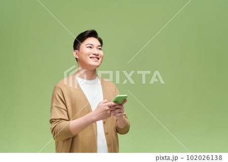 Happy asian young man using smart phone cellphone for calls Happy asian young man using smart phone cellphone for calls 102026138
