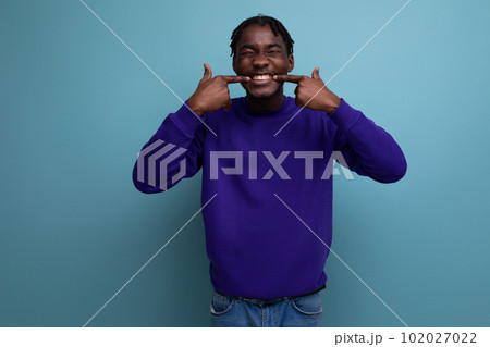 portrait of funny smiling american young adult in blue hoodie and jeans isolated on plain background portrait of funny smiling american young adult in blue hoodie and jeans isolated on plain background 102027022