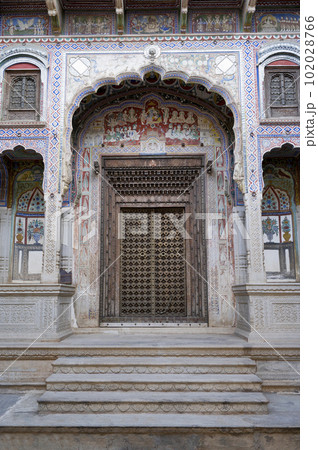 Fresco paintings and carved wooden door of Kamal Morarka Haveli Museum in Shekhawati. Marwari merchants constructed grand havelis in the Shekhawati region dated 17th to 19th centuries richly decorated 102028766