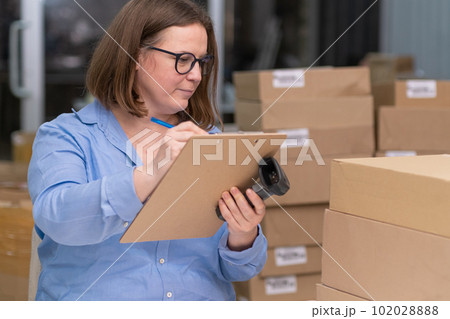 online store concept. SME businesswoman who sells products online, tracking orders and managing packaging materials for her small business 102028888