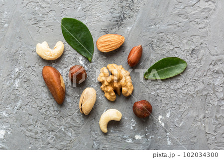 Composition of nuts , flat lay - mix hazelnuts, cashews, almonds on table background. healthy eating concepts and food background 102034300