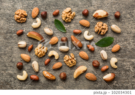 Composition of nuts , flat lay - mix hazelnuts, cashews, almonds on table background. healthy eating concepts and food background 102034301