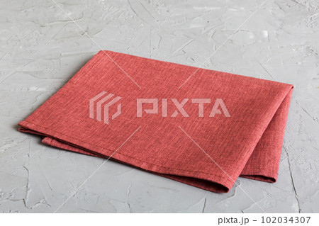 top view with red empty kitchen napkin isolated on table background. Folded cloth for mockup with copy space, Flat lay. Minimal style 102034307