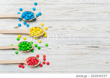 delicious colorful sweet candies on spoon on colored background . Confectionery decor top view with copy space delicious colorful sweet candies on spoon on colored background . Confectionery decor top view with copy space 102034337