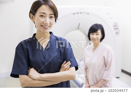CTの前で腕組みをする放射線技師と患者 CTの前で腕組みをする放射線技師と患者 102034477