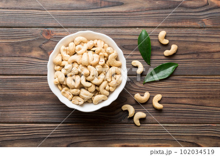 cashew nuts in wooden bowl on table background. top view. Space for text Healthy food 102034519