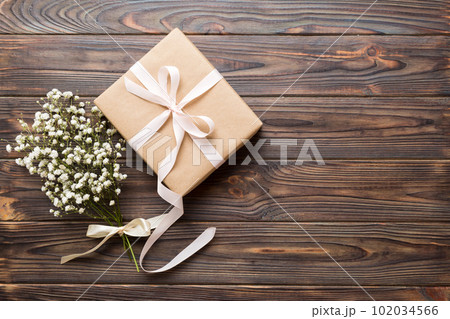 Gift or present box and flower gypsophila on light table top view. Greeting card. Flat lay style with copy space 102034566