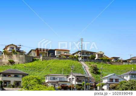青空を背景にした丘陵地の新興住宅地 102039049