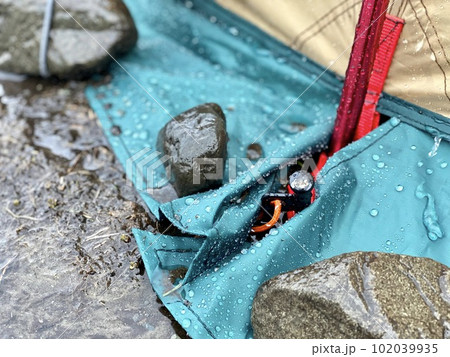 雨のテントのスカートを押さえる石とペグ 雨のテントのスカートを押さえる石とペグ 102039935