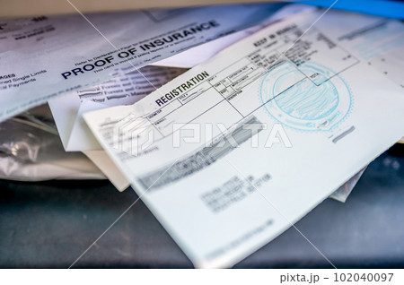 Proof of insurance and vehicle registration documents in the glove compartment of a car.  102040097