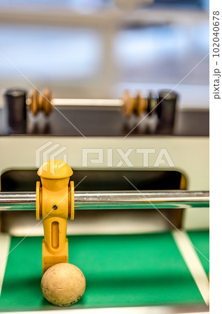 Selective focus on a foosball goalie blocking the ball insider the box. 102040678