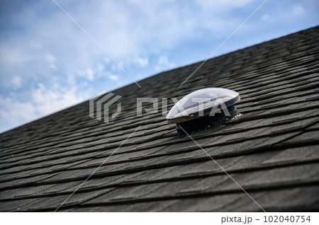 Dome shaped solar tube skylight on asphalt shingle roof Dome shaped solar tube skylight on asphalt shingle roof 102040754