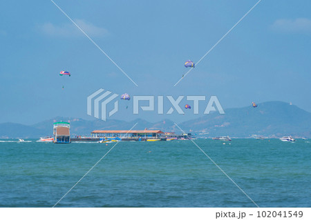 People flying in a colorful parachute or parasail together with blue sky and clouds in freedom and travel concept. 102041549