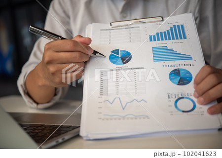 businessmen pen pointing to graphs and report on table, financial accounts, market economy. 102041623