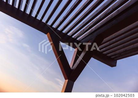 Wooden sunshade roof is under blue sky 102042503