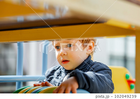The kid plays in a nursery. Children are enjoying playground equipment 102049239