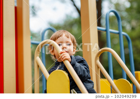 Portrait of happy child outdoors. Cute boy playing on playground. Portrait of happy child outdoors. Cute boy playing on playground. 102049299