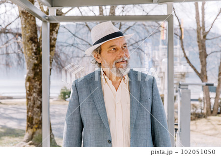 Portrait of a confident, handsome, mature man, pensioner, grandfather in the small town Portrait of a confident, handsome, mature man, pensioner, grandfather in the small town 102051050