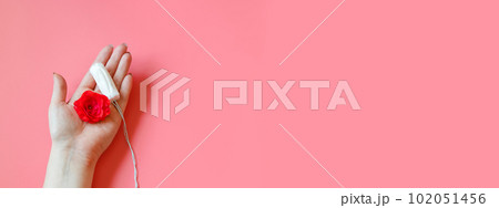 Womans hand holds hygienic cotton tampon. Concept of intimate hygiene and health. Copy space. Womans hand holds hygienic cotton tampon. Concept of intimate hygiene and health. Copy space. 102051456