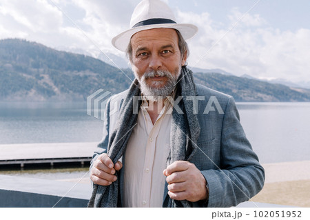 Portrait of a confident, handsome, mature man, pensioner, grandfather in the small town Portrait of a confident, handsome, mature man, pensioner, grandfather in the small town 102051952
