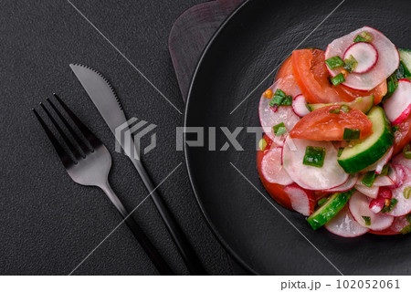 Delicious vegan salad of fresh vegetables of tomatoes, cucumbers and radishes Delicious vegan salad of fresh vegetables of tomatoes, cucumbers and radishes 102052061