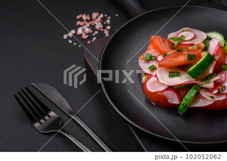 Delicious vegan salad of fresh vegetables of tomatoes, cucumbers and radishes Delicious vegan salad of fresh vegetables of tomatoes, cucumbers and radishes 102052062